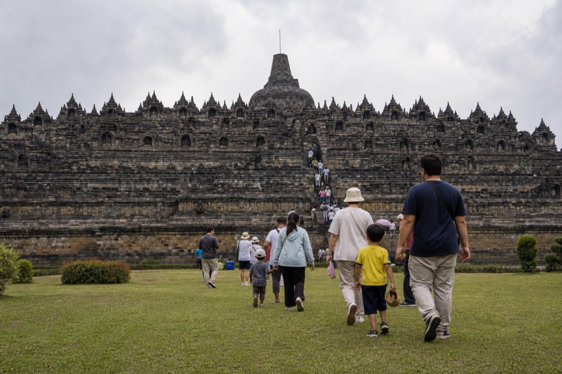 A family climbing the terraces of Borobudur temple
