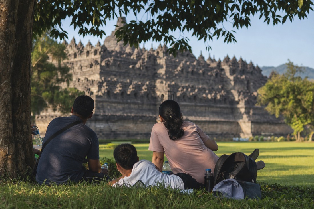 A family resting in the shade below Borobudur temple