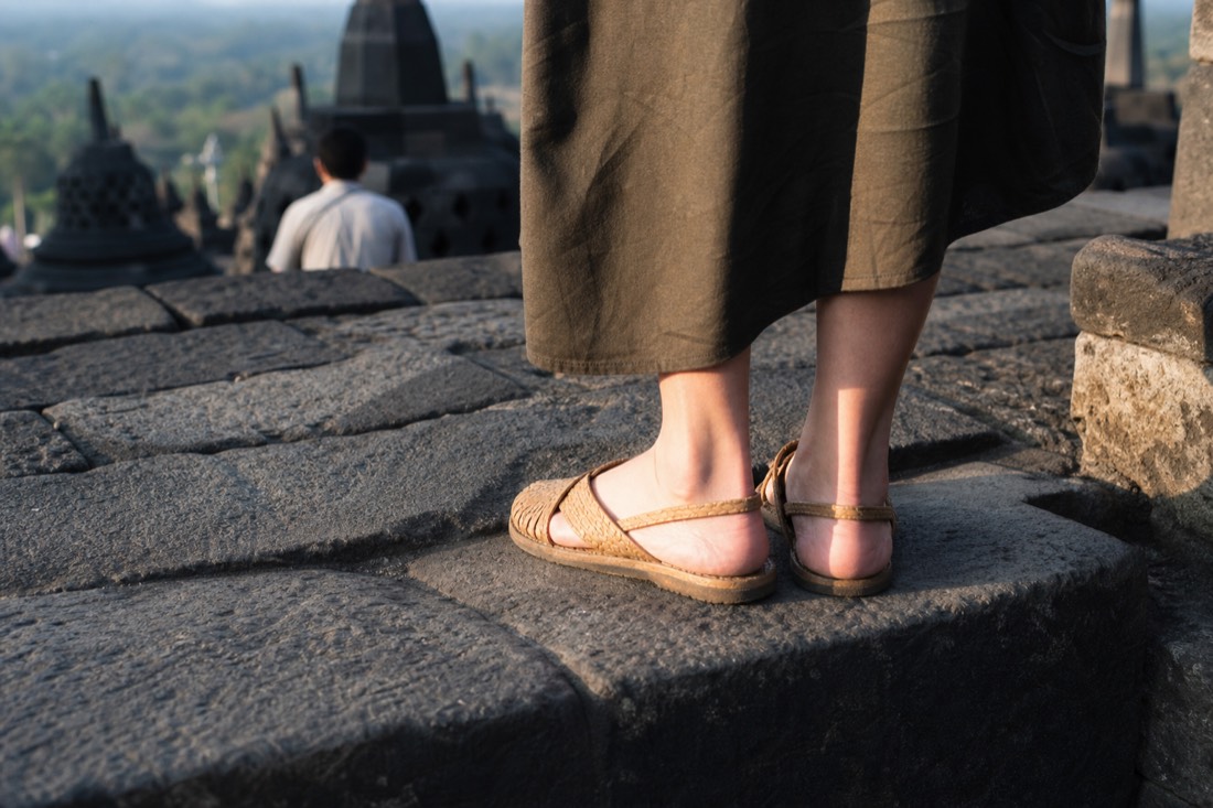 Woven sandals on the worn stone of Borobudur