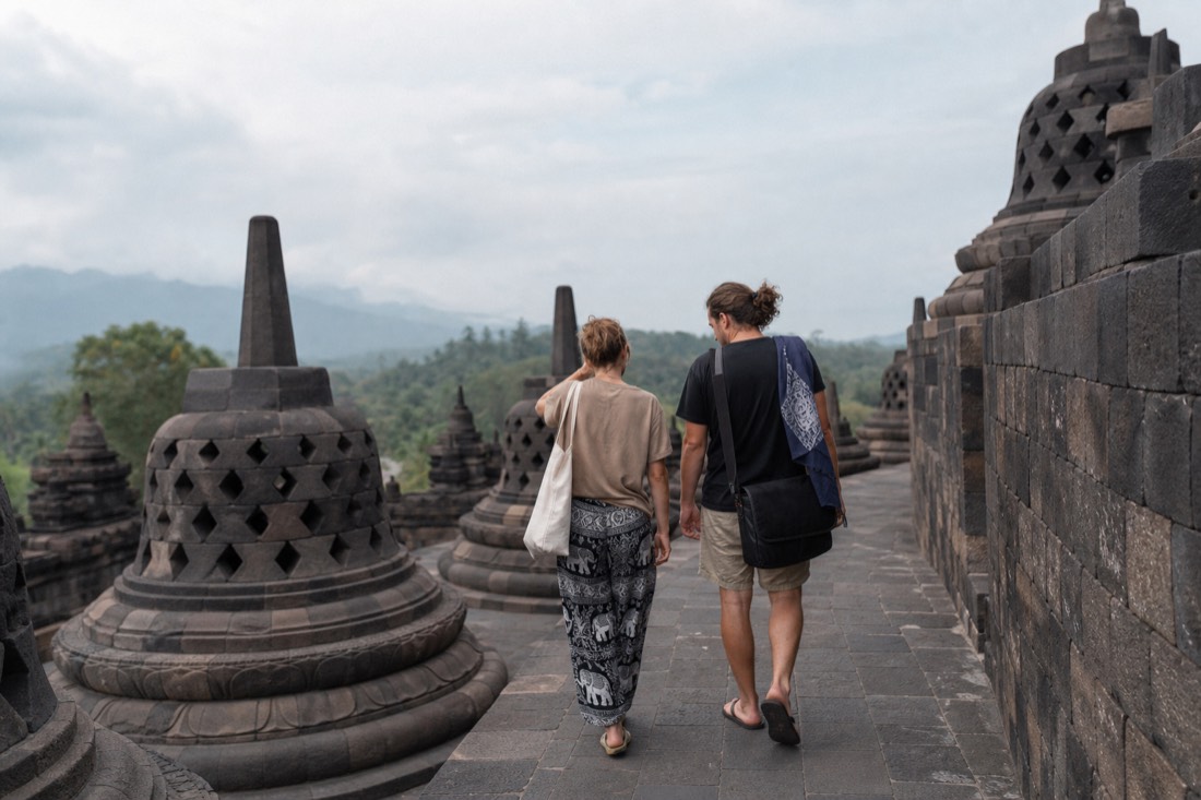 Two visitors dressed differently climbing Borobudur