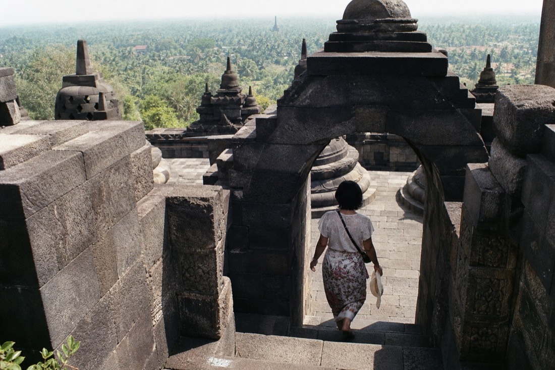 Ascending through a carved gateway arch at Borobudur