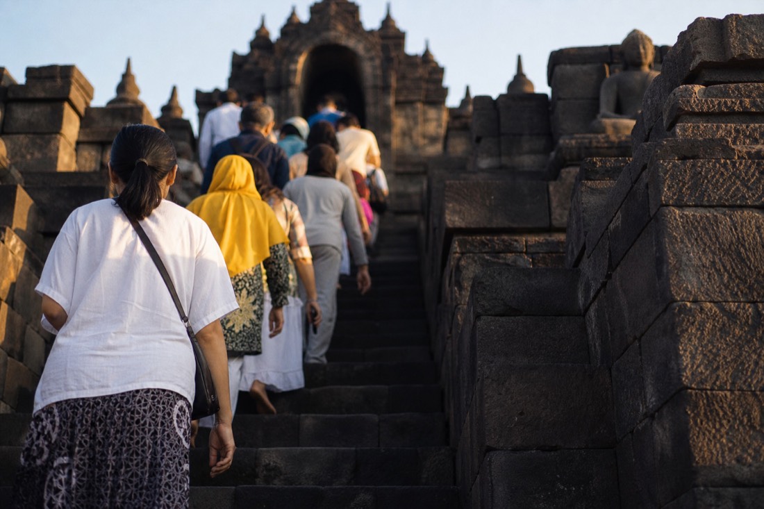 Climbing the steep stone stairway of Borobudur temple