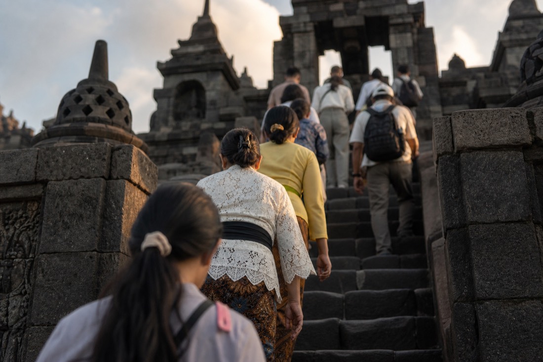 Climbing the steep stone stairway of Borobudur temple