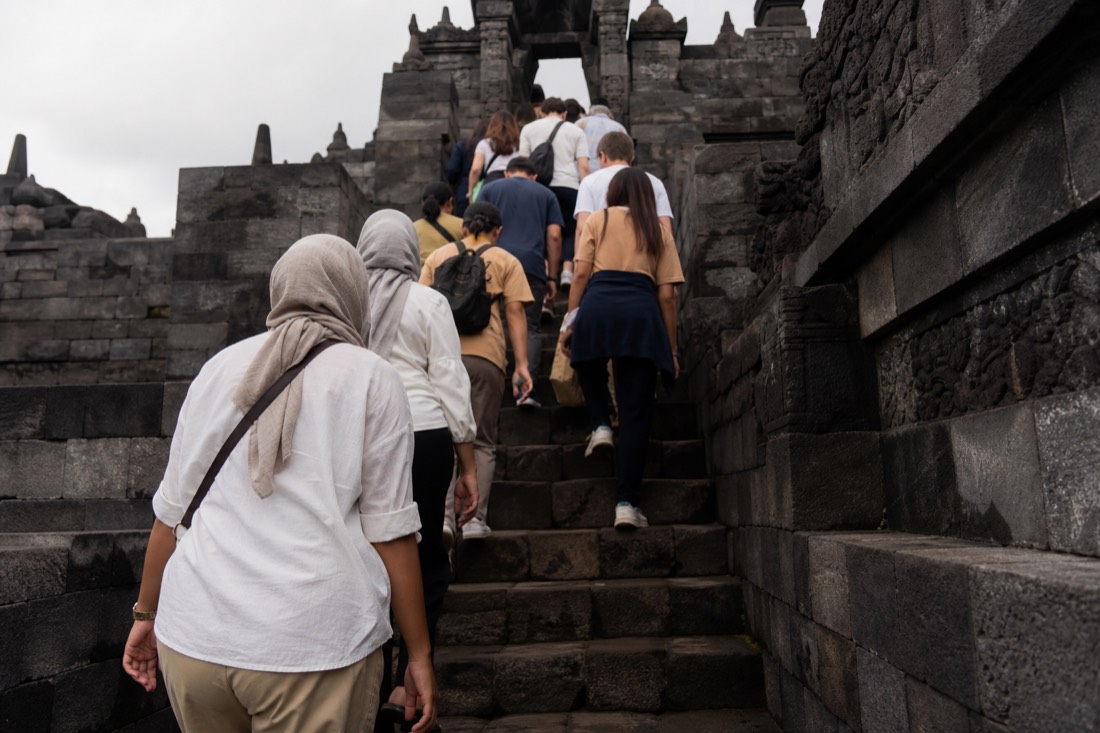 Climbing the steep stone stairway of Borobudur temple