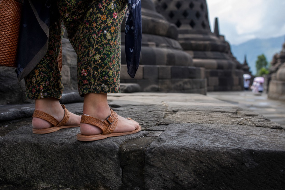 Woven sandals on the worn stone of Borobudur